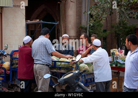 Kashgar, Xinjiang, Chine - le 14 août 2012 : Groupe d'hommes Ouïghours à un marché de rue dans la ville de Kashgar, Xinjiang, Chine Banque D'Images