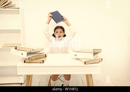 Dans l'humeur capricieuse. Mec être bruyant à l'école. Petit enfant qui refuse d'apprendre l'alphabétisation. Petite fille livre sensibilisation sur la tête. Angry girl reading book déteste. Lycéenne ayant leçon de littérature. Banque D'Images