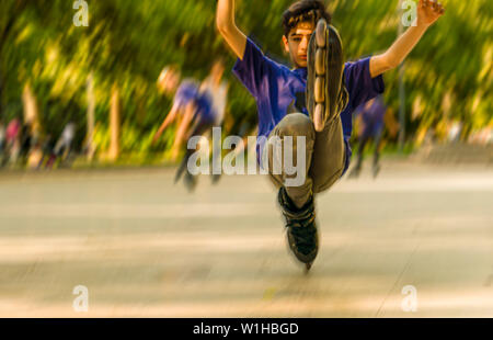 Ankara/Turkey-June 23 2019 : Abstract blurred boy joue le truc sur les patins à roulettes. Se déplace sur une jambe dans un squat Banque D'Images