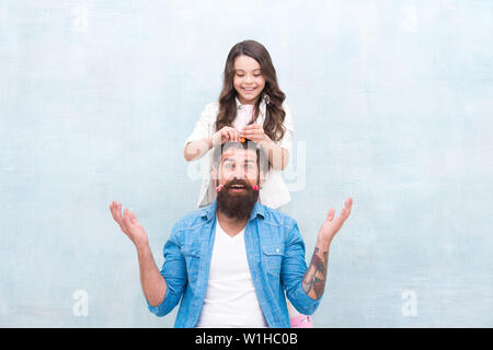 Changer de coiffure. Avec bonne dose d'ouverture n'importe quel père peut exceller à sensibiliser le jeune fille. Créer drôle de coiffure. Enfant faisant hairstyle styling père barbe. Être parent signifie présenter pour leurs intérêts. Banque D'Images