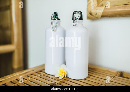 Deux bouteilles métalliques réutilisables blanc sur la table en bambou. Eco Friendly et concept zéro déchet. Banque D'Images