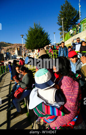 La Paz, Bolivie 2 Juillet 2019 : une femme Aymara portant son bébé observe une éclipse partielle du soleil à travers un télescope sur une éclipse regarder événement près du centre-ville. À La Paz l'éclipse a duré environ 2 heures 10 minutes avec environ 55 % de couverture à son maximum. Banque D'Images