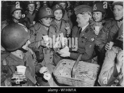 Photographie de femmes américaines de remplacer ces hommes qui se battaient en Europe ; la portée et contenu : la légende originale : les femmes américaines remplacer la lutte contre les hommes en Europe. Les membres de l'United States Army Corps (WAC) recevoir des friandises d'un travailleur de la cantine de la Croix-Rouge américaine pendant qu'ils attendent à bord d'un navire pour l'Europe en mai 1945. Que la lutte contre les hommes de le théâtre européen ont été redéployés dans le Pacifique, le WAC alla à les remplacer dans certains emplois et aide ainsi les forces d'occupation. Dans un nombre toujours croissant de femmes vont également dans le Pacifique, où le total de 5000 déjà en service serait bientôt s Banque D'Images