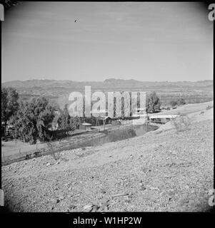 Poston, Arizona. Au premier plan on peut voir le canal d'irrigation qui fournira à l'aide d'une . Poston . . ; Portée et contenu : la légende complète pour cette photographie se lit comme suit : Poston, Arizona. Au premier plan on peut voir le canal d'irrigation qui fournira de l'eau agricole avec Poston. Ce canal reçoit son eau du barrage Parker. Dans l'arrière-plan, on peut voir le fleuve Colorado. Banque D'Images