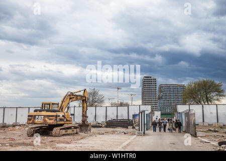 BELGRADE, SERBIE - 31 mars 2018 : les gens qui passent par une excavatrice Cat dans la construction de l'emplacement de Beograd, na Vodi une controversed p d'affaires gratte-ciel Banque D'Images