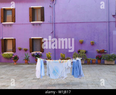 Blanchisserie lavé frais accroché au milieu de la cour en face de la chambre pourpre dans l'île de Burano, Venise Banque D'Images