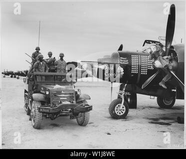 Le Sgt. Ben A. Robertson, Henderson, au Texas, de son perchoir à cheval sur l'hélice de ce cinquième Air Force RB-26 bombardier léger de la 67e Escadre de reconnaissance tactique, les vagues d'un message d'accueil à une unité anti-aérienne sur le chemin de leurs positions de la colline à un stade avancé de Korean Air base. La protection de la piste d'une attaque aérienne de l'ennemi est le devoir de ce 24 heures, et d'autres équipages. Banque D'Images