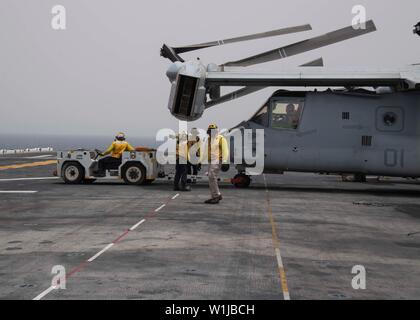 190701-N-FG333-1048 GOLFE D'ADEN (1 juillet 2019) marins affectés au navire d'assaut amphibie USS Boxer (DG 4) déplacer un MV-22B Osprey affecté à rotors basculants moyen maritime (VMM) de l'Escadron 163 (renforcé) dans le poste de pilotage. Boxer Boxer fait partie du groupe amphibie et 11e Marine Expeditionary Unit et est déployé sur le 5e flotte américaine zone d'opérations à l'appui des opérations navales pour assurer la stabilité et la sécurité maritime dans la région Centrale, reliant la Méditerranée et le Pacifique à travers l'ouest de l'Océan indien et trois points d'étranglement stratégiques. (U.S. Photo de la marine en masse Comm Banque D'Images