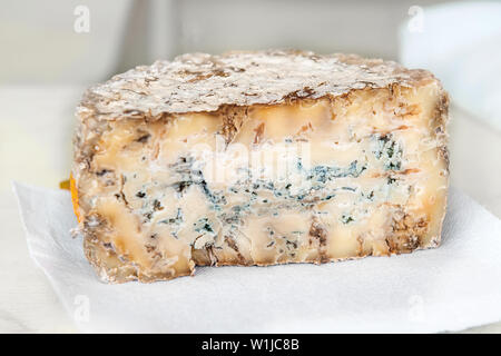 Une tranche de fromage stilton bleu de charcuterie sur un tableau blanc. La qualité des produits agricoles. Banque D'Images