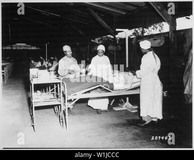 Salle de chirurgie à la station de base, de l'hôpital la 268 A, Milne Bay, Nouvelle Guinée. De gauche à droite : sgt. Laurent McKreever, patient ; Prudence lieutenant Burns, infirmière de salle ; le lieutenant Elcena Townscent 2e chef, infirmière en chirurgie ; et une infirmière non identifiés., 06/22/1944 Banque D'Images