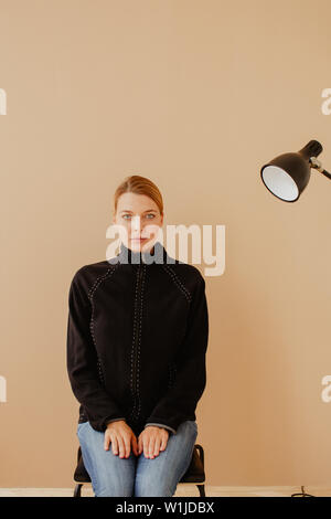 Short-haired woman en fauteuil devant studio light Banque D'Images