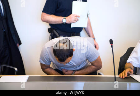 Bad Kreuznach, Allemagne. 06Th Juillet, 2019. Le défendeur prend sa place dans les menottes dans la salle d'audience. C'est le début du procès contre le peuple afghan demandeur d'asile de Biblis, dont il est dit qu'il a poignardé la mère-à-être de l'enfant ensemble. Dans l'acte en janvier de cette année, les 25 ans a été grièvement blessé, l'enfant à naître a été tué. Crédit : Andreas Arnold/dpa/Alamy Live News Banque D'Images