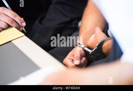 Bad Kreuznach, Allemagne. 06Th Juillet, 2019. Le défendeur est menotté dans la salle d'audience. C'est le début du procès contre le peuple afghan demandeur d'asile de Biblis, dont il est dit qu'il a poignardé la mère-à-être de l'enfant ensemble. Dans l'acte en janvier de cette année, les 25 ans a été grièvement blessé, l'enfant à naître a été tué. Crédit : Andreas Arnold/dpa/Alamy Live News Banque D'Images