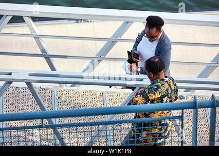 Montréal, Canada - Juin 2018 : African American middle age man and woman chatting et marche sur l'escalier au vieux port de Montréal, Canada. Banque D'Images
