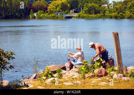 Montréal, Canada - Juin 2018 : personnes âgées couple canadien pêcheur assis près de la rivière et la pêche dans les rapides de Lachine, Montréal, Québec, Canada. Banque D'Images