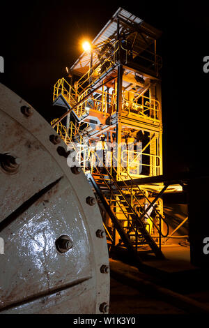 Exploitation minière pour le transport et la gestion du minerai de fer. Intérieur de l'usine de test saprolite à l'aube et opérateur réglant la spirale sur le concentrateur cyclone. Banque D'Images