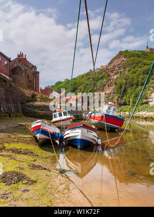 Marée basse à Staithes, et bateaux de pêche amarrés dans le beck à la mi-été. Banque D'Images