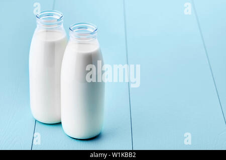 Deux bouteilles de lait en bois bleu sur table rétro. Vue en gros plan. Banque D'Images