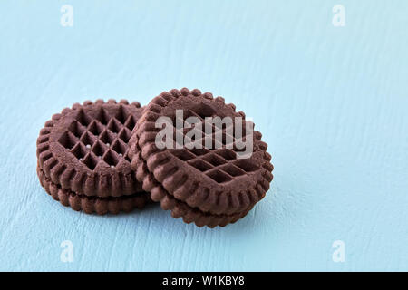 Deux crème au chocolat rempli de biscuits sur la table en bois bleu. Close up macro-vision. Banque D'Images