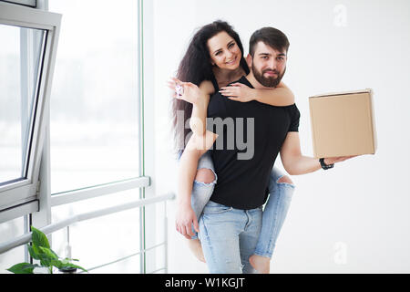 Jeune couple heureux de parler tout en se tenant à leur nouvelle maison Banque D'Images