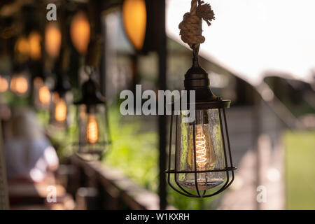 Description : Décoration Vintage l'éclairage. Lampe en métal avec lampe à l'ancienne suspendu par une corde épaisse Banque D'Images