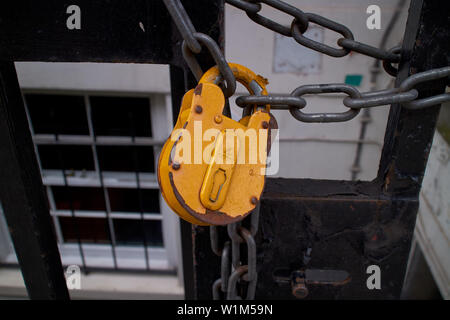 Un gros cadenas jaune vif, détenant ensemble une solide chaîne. Banque D'Images