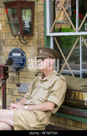 Kidderminster, UK. 29 Juin, 2019. Severn Valley Railways l'étape retour vers les années 40' s'équipe d'un fabuleux début de ce week-end avec des reconstitutions historiques costumés jouer leur rôle en fournissant une authentique re de la Grande-Bretagne pendant la guerre. L'homme isolé en uniforme kaki de l'armée est assis sur un banc dans une gare vintage attendent patiemment l'arrivée du prochain train à vapeur. Credit : Hudson Lee Banque D'Images