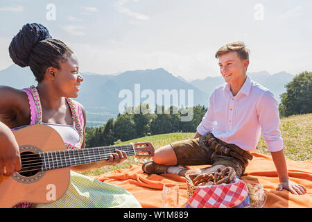 Teenage friends enjoying avec guitare lors de pique-nique, Bavière, Allemagne Banque D'Images