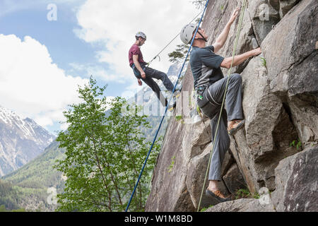 Deux hommes des grimpeurs à l'échelle d'une paroi rocheuse à Oberried jardin d'escalade, l'Otztal, Tyrol, Autriche Banque D'Images