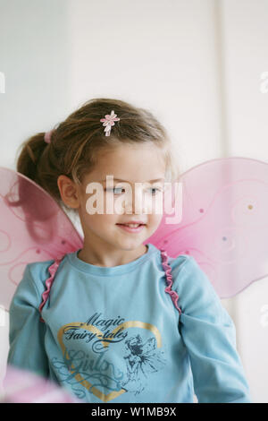 Girl (3-4 ans) portant des ailes de papillon Banque D'Images