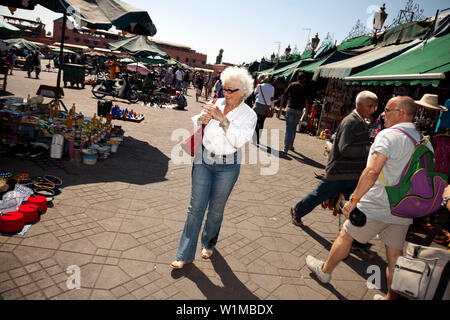 Femme marche dans la place du marché, de la place Jemaa el Fna, Marrakech, Maroc Banque D'Images