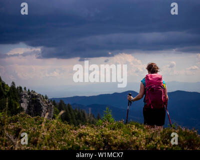 Randonneur femmes permanent au-dessus de montagnes vers valley au Col de la Schlucht dans les Vosges, Alsace, France Banque D'Images