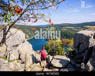 Vue arrière du randonneur à la vue des femmes en forêt de bord au-dessus de Hans rock au Lac Blanc Rocher Hans, France Banque D'Images