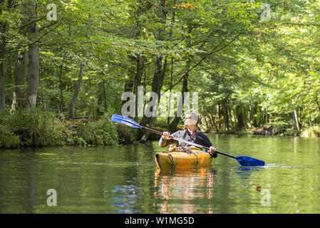 Kayak kayak de tourisme sur une branche d'eau. Le soleil brille à travers la forêt, réserve de biosphère, Schlepzig, Brandenburg, Allemagne Banque D'Images