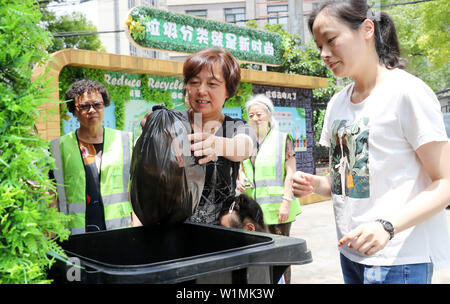 (190703) -- BEIJING, 3 juillet 2019 (Xinhua) -- le tri des ordures des bénévoles aident à un résident pour trier les déchets en une communauté dans le district de Zhabei de Shanghai, la Chine orientale, le 24 juin 2019. (Xinhua/Fang Zhe) Banque D'Images