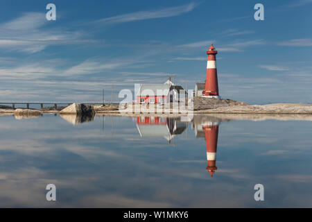 Le phare rouge Tranøy Fyr sur une journée ensoleillée avec son reflet dans la mer, à Tranøya, Hamarøy, Nordland, Norvège, Scandinavie Banque D'Images