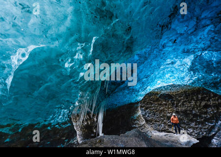 Homme avec piolet en bleu ci-dessous la grotte de glace de glacier de Vatnajokull, Breidamerkursandur entre le parc national de Skaftafell und Hofn, est de l'Islande, Islande, Euro Banque D'Images
