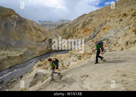 Les jeunes hommes, les randonneurs, trekkeurs dans le typique paysage surréaliste pour Mustang dans le désert autour de la haute vallée de la Kali Gandaki, la plus profonde vallée dans le Banque D'Images