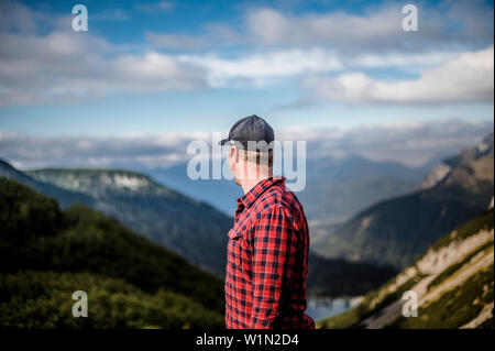 Homme regardant au loin au-dessus du lac Seebensee, gamme de Mieming, région Zugspitze, Alpes, Tyrol, Autriche Banque D'Images