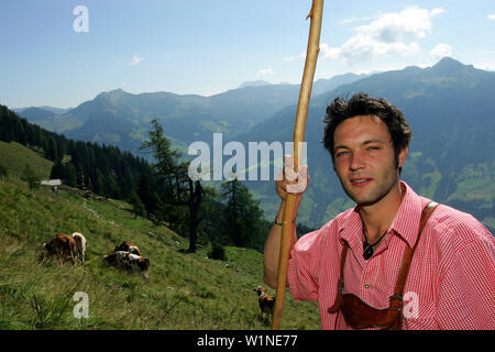 Dairyman habillé dans le style typique des Alpes, s'occupe des jeunes bovins sur les Prairies du Viehausalm, Nationalpark Hohe Tauern, Salzburge Banque D'Images