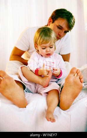 Little girl holding son pied Banque D'Images