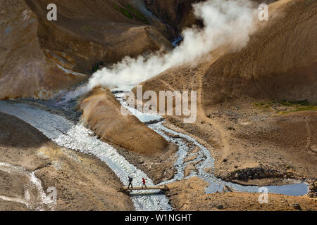 Les randonneurs traverser le pont dans la zone géothermique de Hveradalir, la vapeur est sortant de montagnes colorées, rhyolith Kerlingarfjoll montagnes volcanoe, Highlands, S Banque D'Images