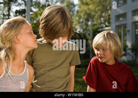 Enfants jouant Chinese whisper, des anniversaires Banque D'Images