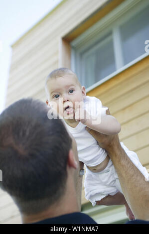 Jeune père holding up baby Banque D'Images