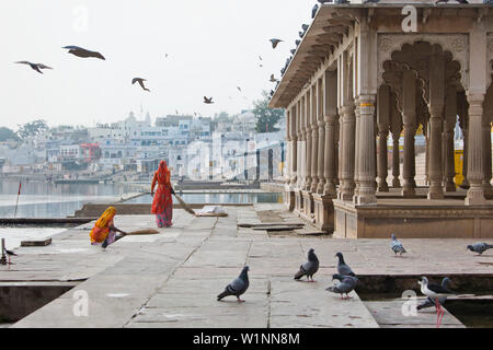 Deux femmes balayant le sol à proximité d'un Ghat, Pushkar, Rajasthan, India Banque D'Images