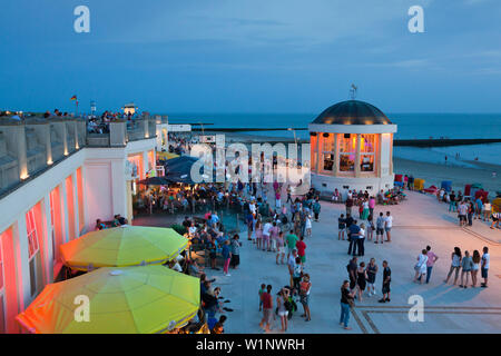 Les gens assis dans un café sur la promenade de la plage, Pavillon dans l'arrière-plan, Borkum, Ostfriesland, Basse-Saxe, Allemagne Banque D'Images