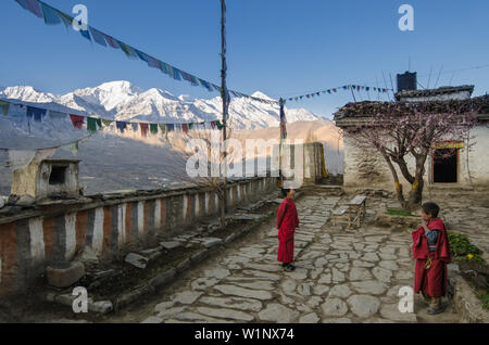 Les jeunes en face de l'monchs Gompa bouddhiste du Dzong, Jhong, village au circuit de l'Annapurna Trek. Dans l'arrière-plan de Nilgiri (7061 m), Pic Tilicho ( Banque D'Images