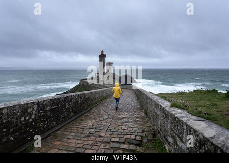 Femme en imperméable jaune marche sur le pont à Phare du petit minou, Plouzané, Brest, Finistère département, Bretagne - Bretagne, France, Europe Banque D'Images