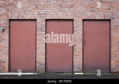 Trois portes en métal rouge brick wall Banque D'Images