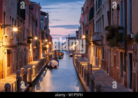 Maisons illuminées à Rio de la Fornace avec des bateaux dans l'Aube bleue, Dorsoduro, Venise, Vénétie, Italie Banque D'Images